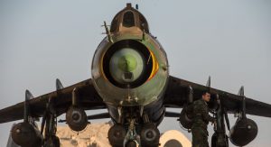 Binh sĩ Syria bên cạnh một chiếc Su-22 mang bom và thùng dầu phụ. Ảnh: Sputnik.